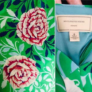 May include: A green dress with a floral pattern featuring large red and white roses and blue and white leaves. The dress has a light blue lining and a tag that reads "Moulinette Soeurs". The size is 6.