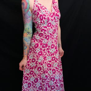 May include: A long pink and white floral print halter dress with a deep V-neckline.