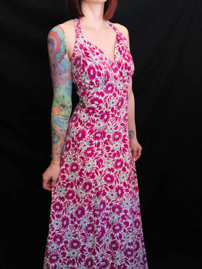 May include: A long pink and white floral print halter dress with a deep V-neckline.