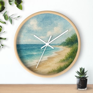 May include: Round wall clock with a watercolor beach scene. The clock face features a blue sky with white clouds, turquoise water, and a sandy beach. The clock has a light wood frame and white hands.