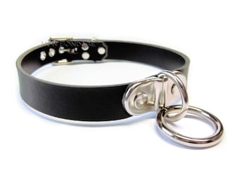 May include: A black leather choker with a silver buckle and a large silver ring attached.