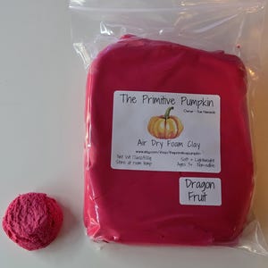 May include: A bag of pink air dry foam clay labeled "The Primitive Pumpkin" and "Dragon Fruit". The clay is soft, lightweight, and non-edible. It is suitable for ages 3 and up. The bag contains 16 ounces (500 grams) of clay.