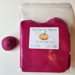 May include: A bag of pink air dry foam clay with a label that reads "The Primitive Pumpkin Air Dry Foam Clay" with a small pumpkin illustration. The label also states "Net Wt 17.6oz/500g Store at room temp Soft + Lightweight Ages 3+ Non-edible".