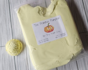 Puede incluir: Una bolsa de arcilla de espuma amarilla que se seca al aire con una etiqueta que dice "The Primitive Pumpkin Air Dry Foam Clay" con una pequeña ilustración de calabaza. La etiqueta también dice "Net Wt 17oz/500g Store at room temp Soft Lightweight Ages 3+ Non-edible".