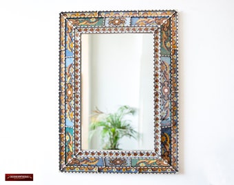 May include: A rectangular mirror with a decorative frame made of colorful mosaic tiles. The frame features intricate floral patterns in shades of blue, yellow, and brown.
