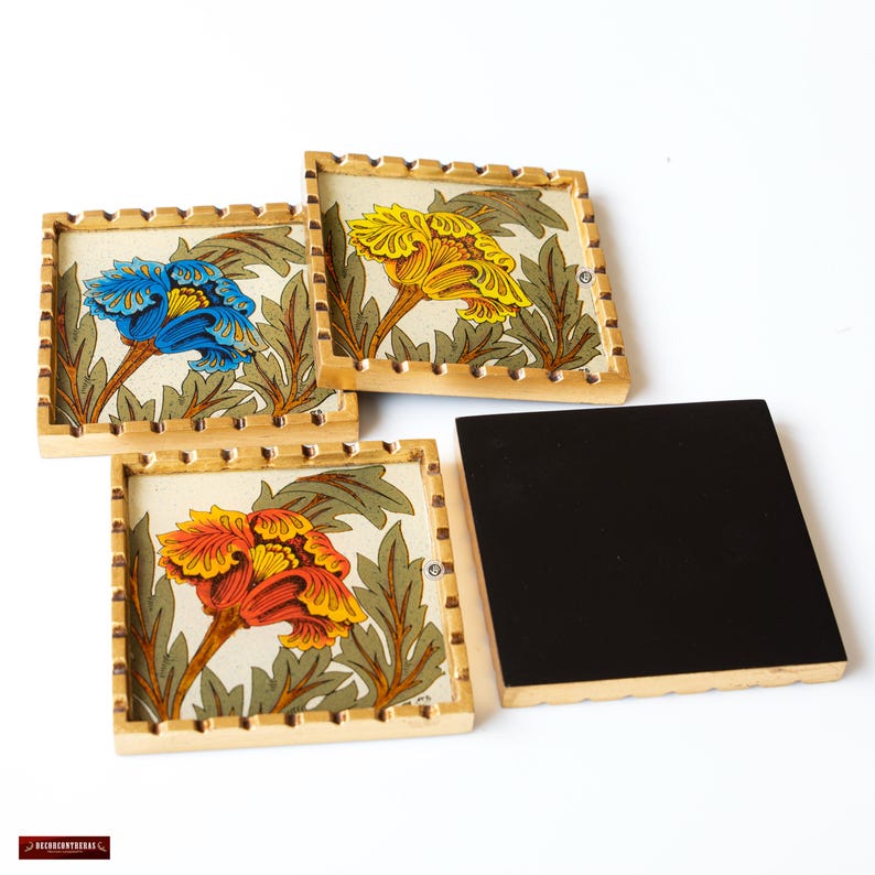 May include: Set of four square coasters with a gold trim and floral designs. The coasters feature a yellow, orange, and blue flower on a white background.