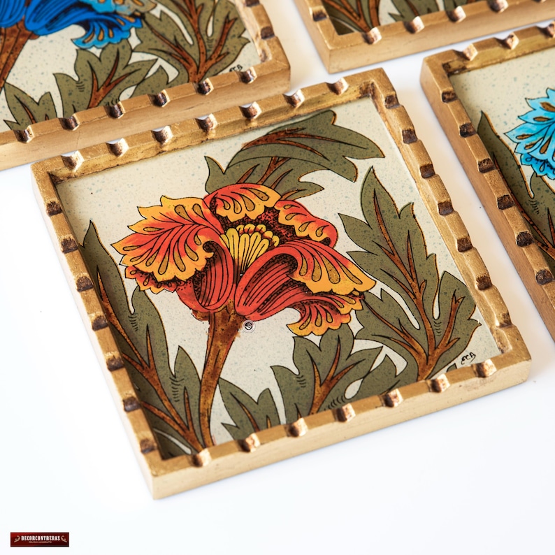 May include: Set of four coasters with a gold frame and a floral design. Each coaster features a different colored flower with a yellow center. The flowers are surrounded by green leaves.