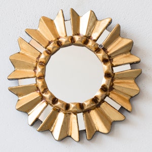 Gold Small Mirror 6-inch, hand-carved Peruvian bronze leaf art by Edmundo Contreras. Sunburst-style MDF frame with hand-cut mirror mosaic fragments on the outer edges. Elegant antique-style wall accent for a gallery wall, handcrafted in Peru. High-quality artisanal home decor.