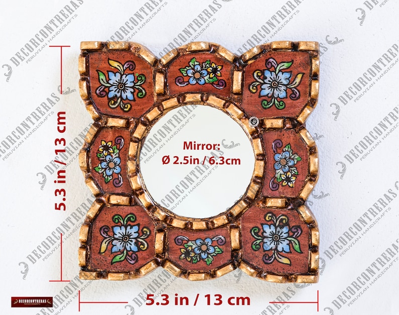 May include: Square decorative mirror, 5.3 inches (13 cm) wide and tall, with a central round mirror, 2.5 inches (6.3 cm) in diameter. The frame is brown with gold accents and floral designs in blue, yellow, and white.