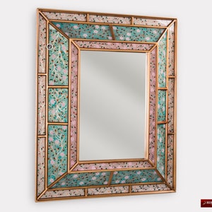 May include: A rectangular mirror with a decorative frame made of mosaic tiles. The frame features a floral pattern in shades of pink, green, and gold.