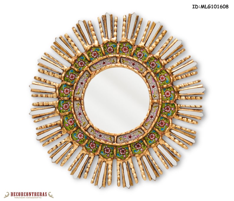 Round sunburst wall mirror of 17.7 inches seen straight on. Two rings of reverse painted glass circle the central mirror: a deep green band of pink and red flowers inside, a colonial ivory arc outside. Gilded carved rays radiate outward with slim mirrored pieces set between them.