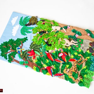 May include: A felt wall hanging depicting a jungle scene with green trees, red parrots, monkeys, and a tiger. The scene is made of felt and sewn together.