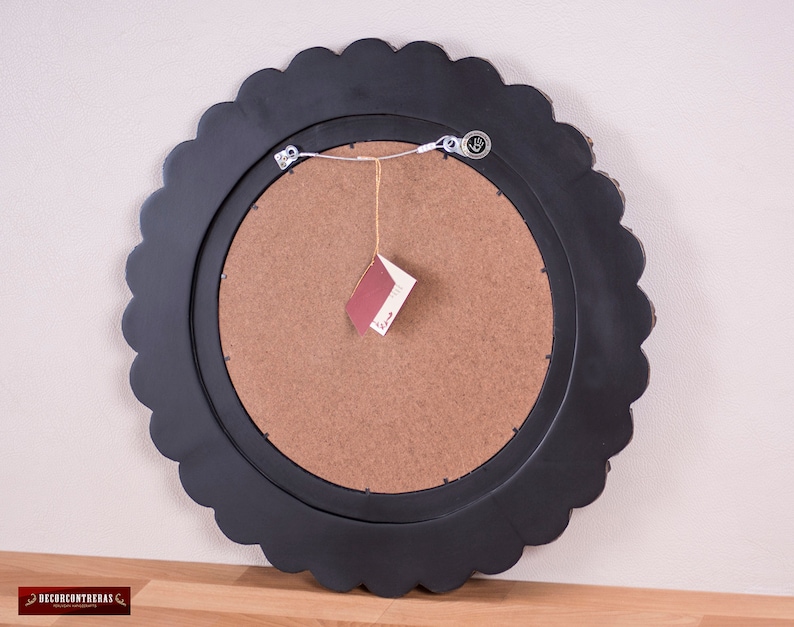 Back of the 23.6in Peruvian wall mirror showing the MDF core and the two metal D-rings fitted with a tensioned steel wire strung between them, so the whole 6.40 lb hangs from a single nail or wall hook, with no extra hardware and no assembly needed on arrival.