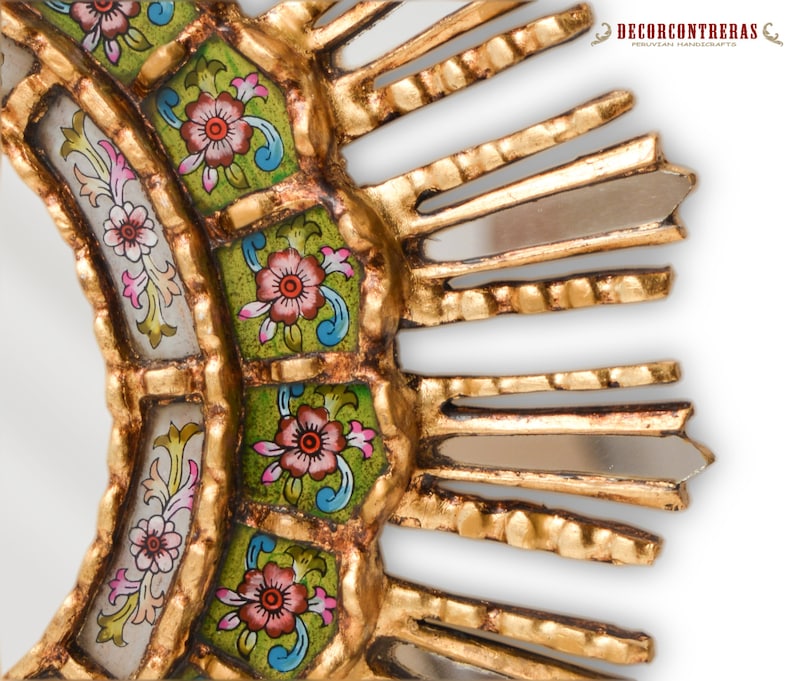 Close view of the painted glass panels on this Peruvian mirror. Each flower is painted on the reverse of the glass, so the glass covers the colour. The gilded wood borders show nogalina settled into the carving, and hand cut mirror strips are inset along the rays.
