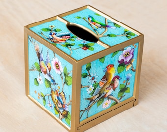 May include: A square tissue box cover with a gold frame and a turquoise background. The cover is decorated with colourful birds and flowers.