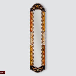 Puede incluir: Un espejo rectangular alto con un marco decorativo. El marco es de madera y tiene un fondo negro con intrincados diseños florales en tonos naranja, amarillo y blanco.
