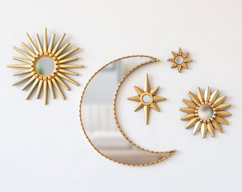 May include: A set of four gold-toned wall mirrors in the shape of a crescent moon, a star, and two suns. The mirrors are decorative and have a vintage aesthetic.