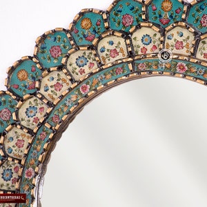 Close detail of the antique gold finish on the scalloped edge of this hand painted Peruvian mirror, showing the metallic worked by hand over a black base beside the layered turquoise brushwork of the colonial floral panels, each one set in its own stepped tier.