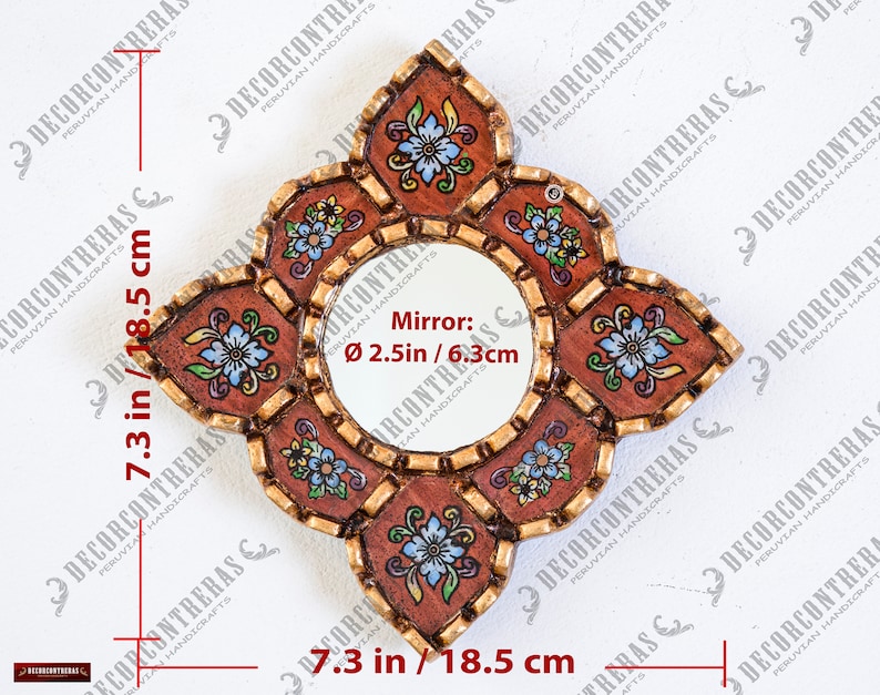 May include: A decorative, handcrafted mirror with a round center and a unique, floral-shaped frame. The mirror is 7.3 inches (18.5 cm) wide and tall, with a 2.5-inch (6.3 cm) diameter mirror. The frame features a brown background with floral designs and gold accents.