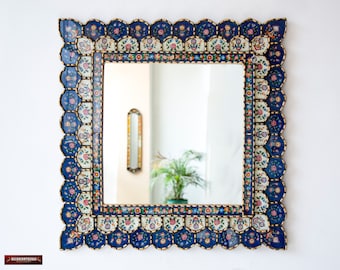 May include: A square wall mirror featuring a decorative frame with a scalloped edge. The frame is composed of hand-painted ceramic tiles in deep blue, white, and gold, adorned with intricate floral patterns in red, green, and orange hues.