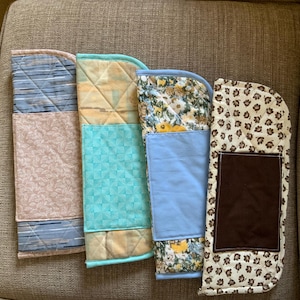 May include: Four rectangular quilted fabric handle covers with rounded top corners. Each cover features a unique combination of patterned and solid fabric sections, including floral, geometric, and striped designs in blue, brown, tan, and pink tones.
