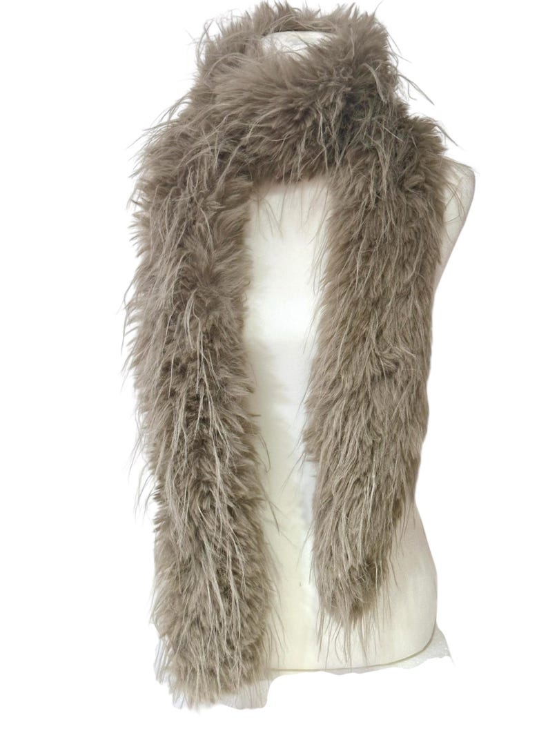 May include: A long, fluffy, taupe-colored boa scarf draped over a mannequin. The scarf is made of soft, feathery material, creating a voluminous and textured appearance. The neutral color makes it a versatile accessory.