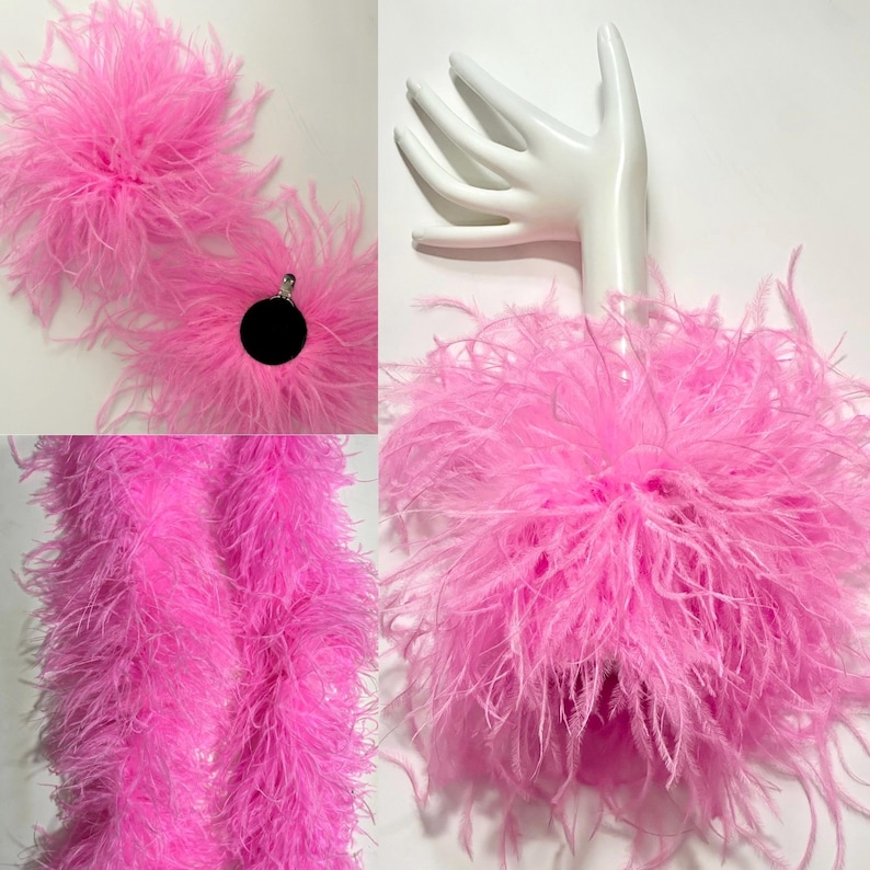 May include: Bright pink feather boa and earrings. The boa is a long, fluffy strand of feathers. The earrings are round with a black center and surrounded by pink feathers. A white hand mannequin holds a pink feather accessory.