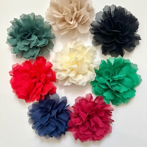 Puede incluir: Surtido de diez adornos de flores de tela en varios colores, incluyendo rojo, verde, crema, beige, azul marino y negro. Las flores son todas del mismo tamaño y forma, con un diseño fruncido y en capas.