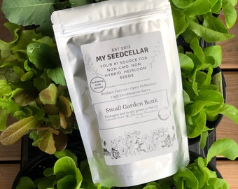 May include: A white resealable bag of seeds labeled "My Seed Cellar" with the text "Your #1 Source for Non-GMO, Non-Hybrid, Heirloom Seeds" and "Replant Forever - Open Pollinated - High Germination Rates". The bag is sitting on a wooden surface surrounded by small green plants.