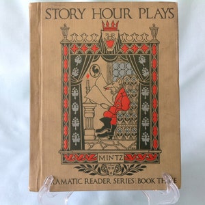 Puede incluir: Libro antiguo titulado "Story Hour Plays" con una cubierta de color beige. La portada presenta una ilustración colorida de un personaje parecido a un zorro con un abrigo rojo leyendo. El libro forma parte de la "Dramatic Reader Series: Book Three".