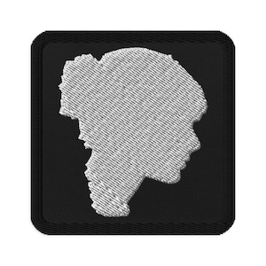 Pode incluir: Um remendo bordado branco com a silhueta da cabeça de uma pessoa sobre um fundo preto.