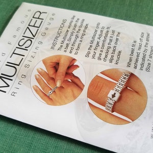 Pode incluir: Uma ferramenta de medi&ccedil;&atilde;o de an&eacute;is de pl&aacute;stico branco com marcas pretas e uma seta vermelha. A ferramenta &eacute; mostrada em uso para medir um dedo. As instru&ccedil;&otilde;es no cart&atilde;o dizem: "O Multisizer funciona como um cinto. Basta empurrar a extremidade atrav&eacute;s da fivela para formar uma forma de anel. Deslize o Multisizer no seu dedo. Ajuste para obter um ajuste confort&aacute;vel, verificando que simplesmente desliza para tr&aacute;s sobre o n&oacute;. Quando o melhor ajuste for alcan&ccedil;ado, leia o tamanho indicado pela seta! (Tamanho 7 mostrado)"