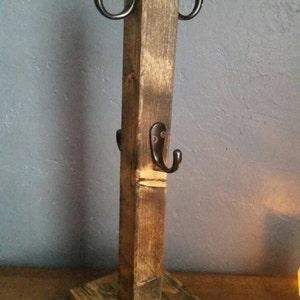 Pu&ograve; includere: Un porta tazze in legno rustico con quattro ganci in metallo nero. Il porta tazze &egrave; realizzato in legno riciclato e ha una finitura naturale.