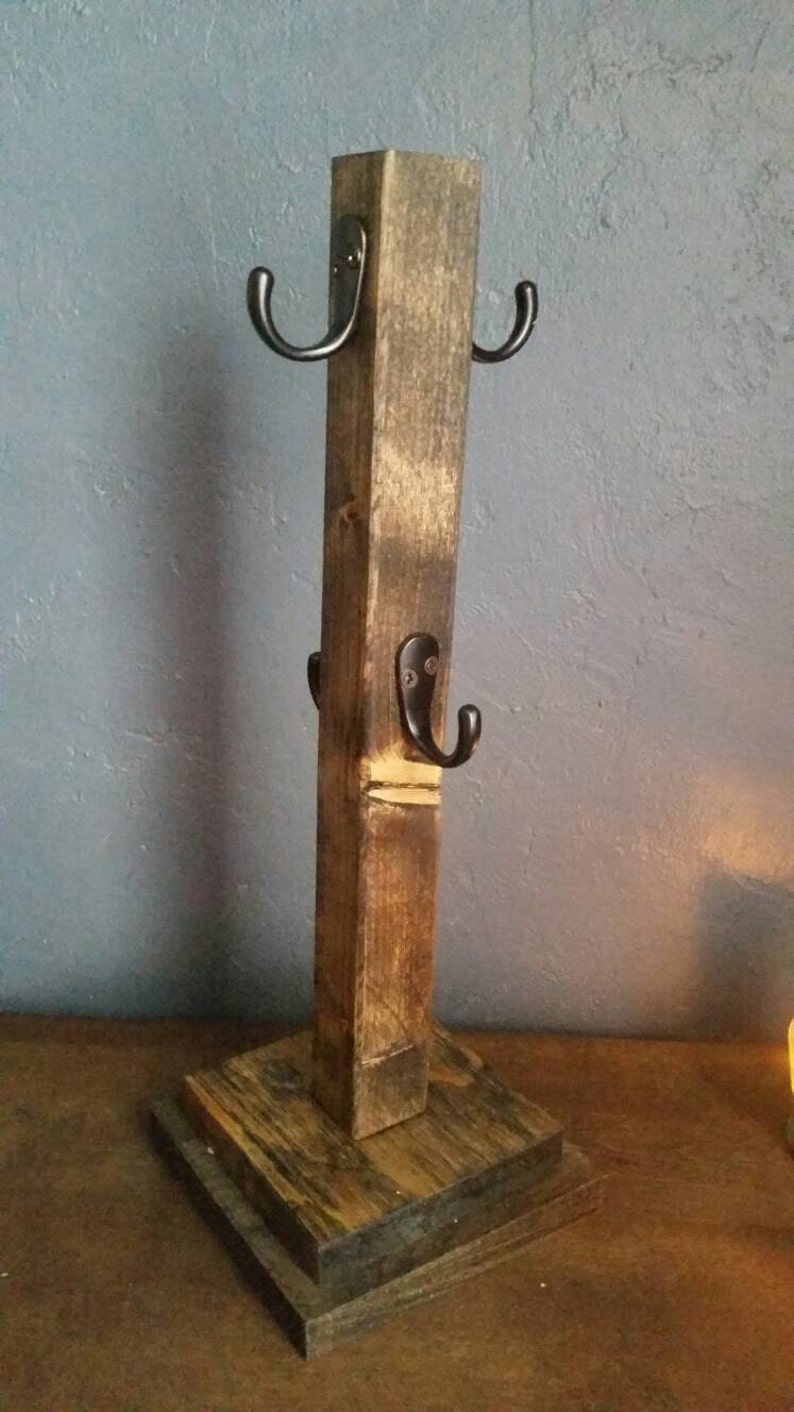 Pu&ograve; includere: Un porta tazze in legno rustico con quattro ganci in metallo nero. Il porta tazze &egrave; realizzato in legno riciclato e ha una finitura naturale.