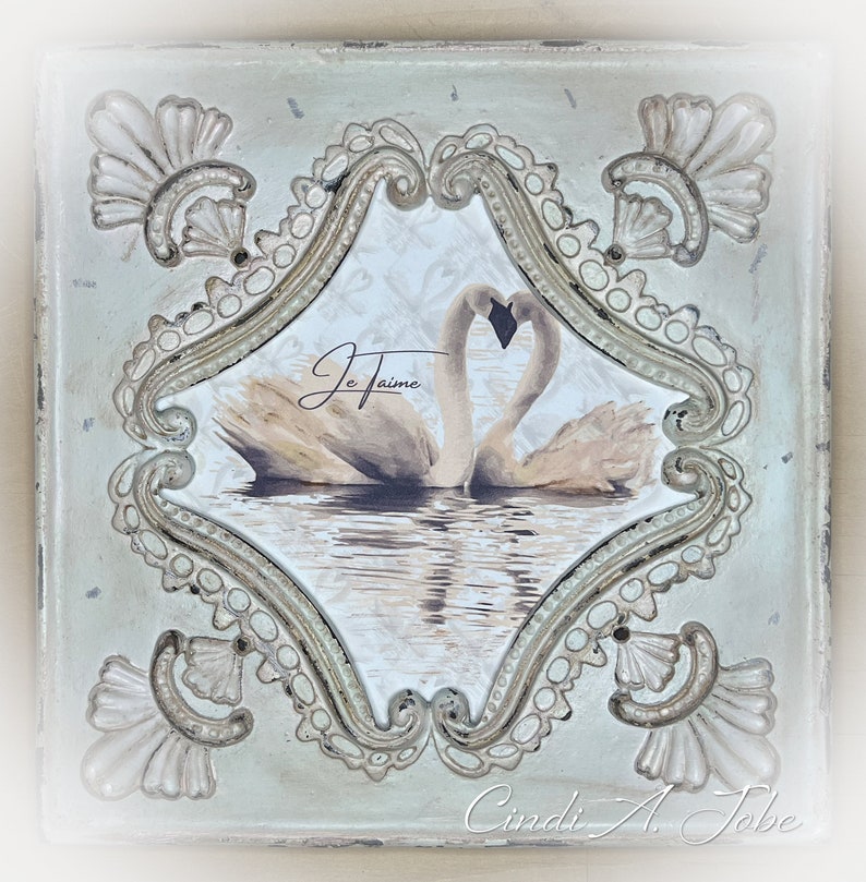 Closeup of Swans in Love print inside distressed frame.