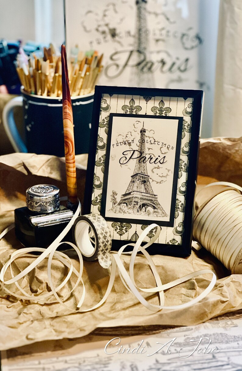 Closeup of Eiffel Tower print in frame on Fleur de lis design. Original is handrawn by me. Background design also by me.