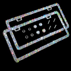 May include: Two silver license plate frames with a sparkling iridescent finish. The frames are adorned with rhinestones and come with screws for installation.