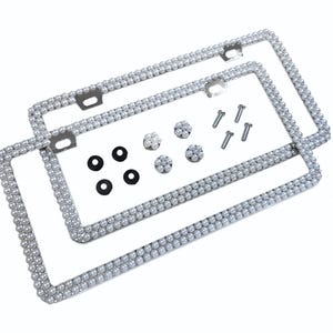 May include: Two silver license plate frames with a pearl design. The frames come with screws and caps for installation.