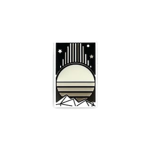 Op de afbeelding: Een zwart-witte sticker met een gestileerd zonsondergangontwerp. Het ontwerp bevat een grote, lichtgekleurde zon, bergen, sterren en verticale lijnen. De sticker heeft een rechthoekige vorm met een witte rand.