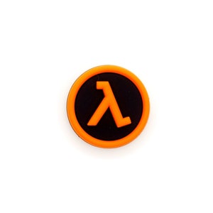 May include: A round orange and black button with the Lambda symbol in the center.