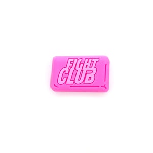 Può includere: Un sapone rosa con le parole "FIGHT CLUB" in rilievo.