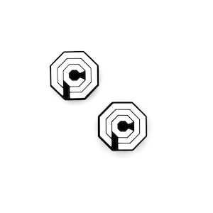 May include: Two black and white octagonal pins with a stylized letter C in the center.
