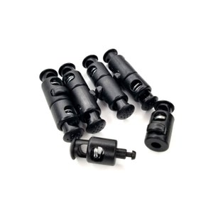 May include: Five black plastic cord locks with a spring mechanism. The cord locks are designed to adjust the length of cords or straps.