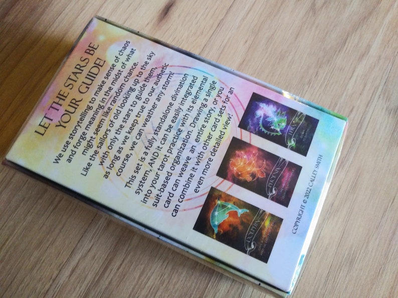May include: A box of Let the Stars Be Your Guide oracle cards. The box features a colorful design with a starry sky and constellations. The back of the box includes a description of the cards and how to use them.