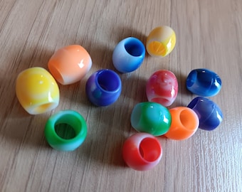 May include: Assortment of colorful plastic beads with a marbled effect. The beads are round and have a hole in the center. The beads are in various colors, including yellow, orange, red, green, blue, and purple.