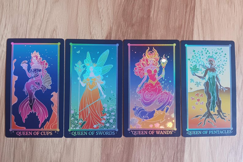 May include: Four tarot cards featuring colorful illustrations of female figures. The cards are labeled "Queen of Cups," "Queen of Swords," "Queen of Wands," and "Queen of Pentacles." Each card has a black border and a holographic effect.