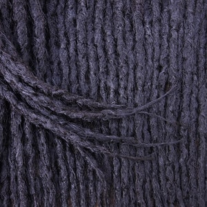 May include: Close-up of black dreadlocks, showing the texture and detail of the hair.