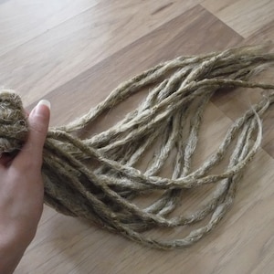 May include: A bundle of light brown synthetic dreadlocks.