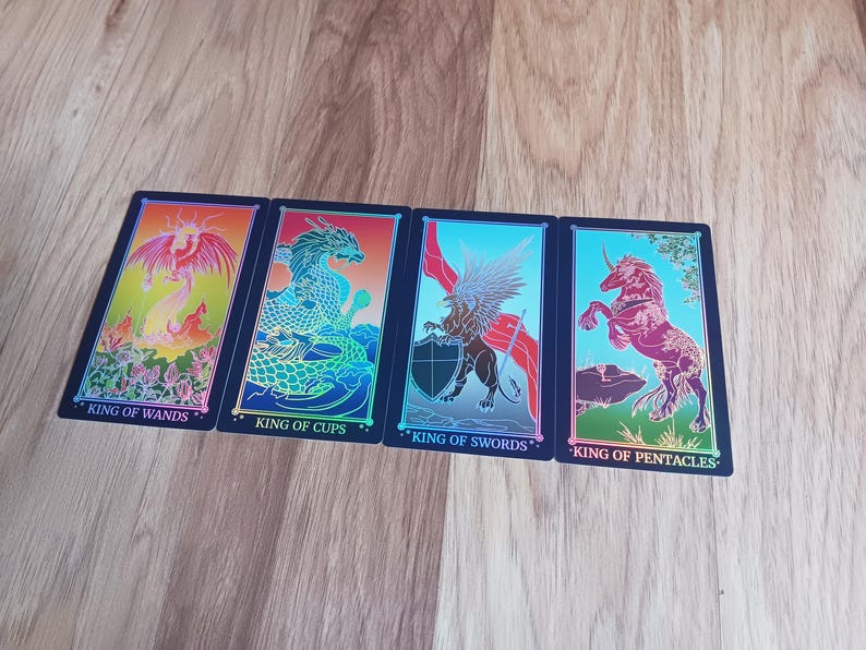 May include: Four tarot cards with colorful illustrations and the words "King of Wands", "King of Cups", "King of Swords", and "King of Pentacles". The cards feature images of a dragon, griffin, and unicorn.