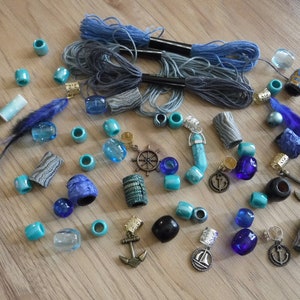 May include: Assortment of blue and turquoise beads, charms, and hair ties.  The charms include anchors, a steering wheel, and a sailboat.  The beads are made of wood, glass, and plastic.  The hair ties are made of fabric and elastic.